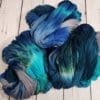 Skeins of blue and grey yarn on a wooden floor.