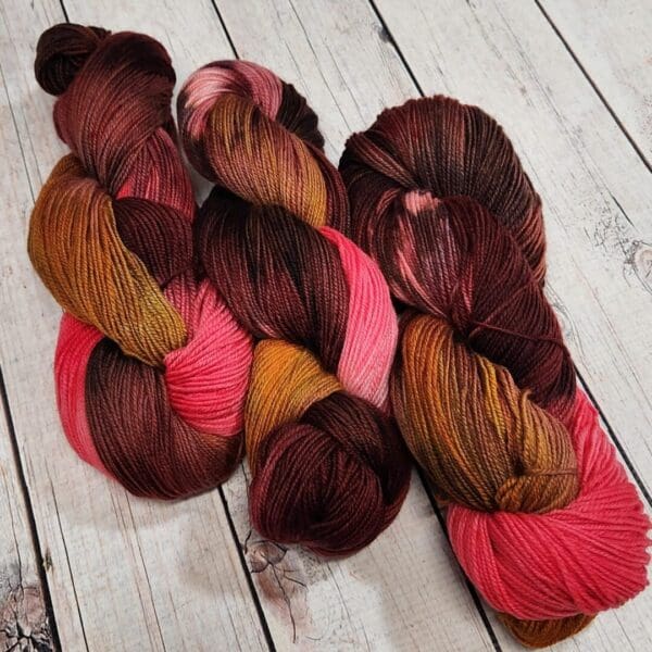 Two skeins of yarn with red and brown colors.