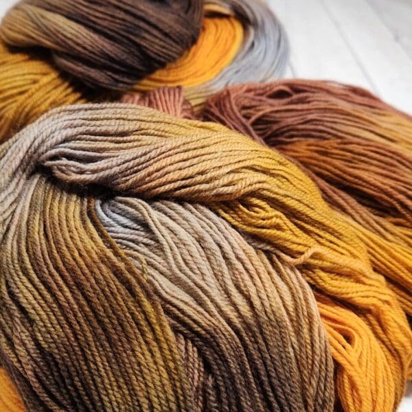 A skein of yarn with brown, yellow, and orange colors.