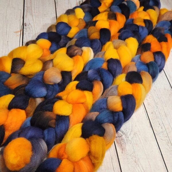 A skein of orange, blue, and yellow roving.