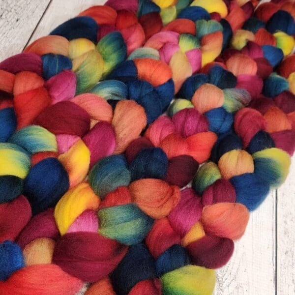 A pile of colorful roving on a wooden table.