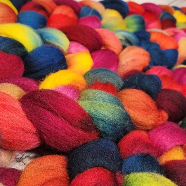 A pile of colorful wool skeins on a table.