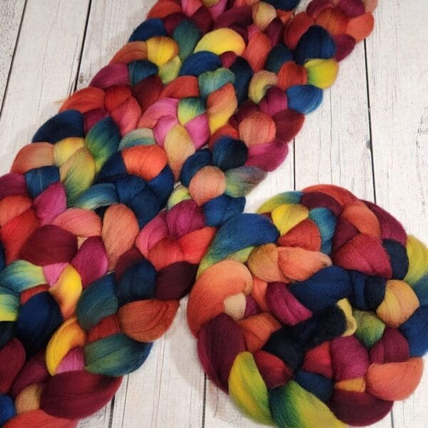 A colorful skein of roving on a wooden table.