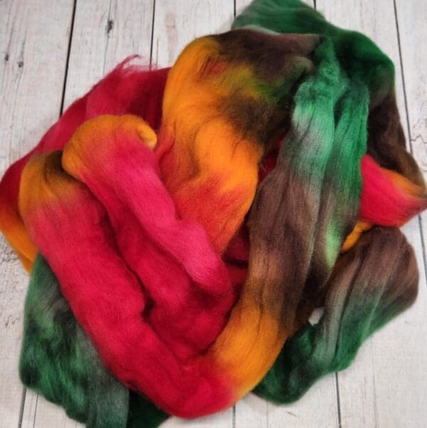 A pile of colorful roving on a wooden surface.