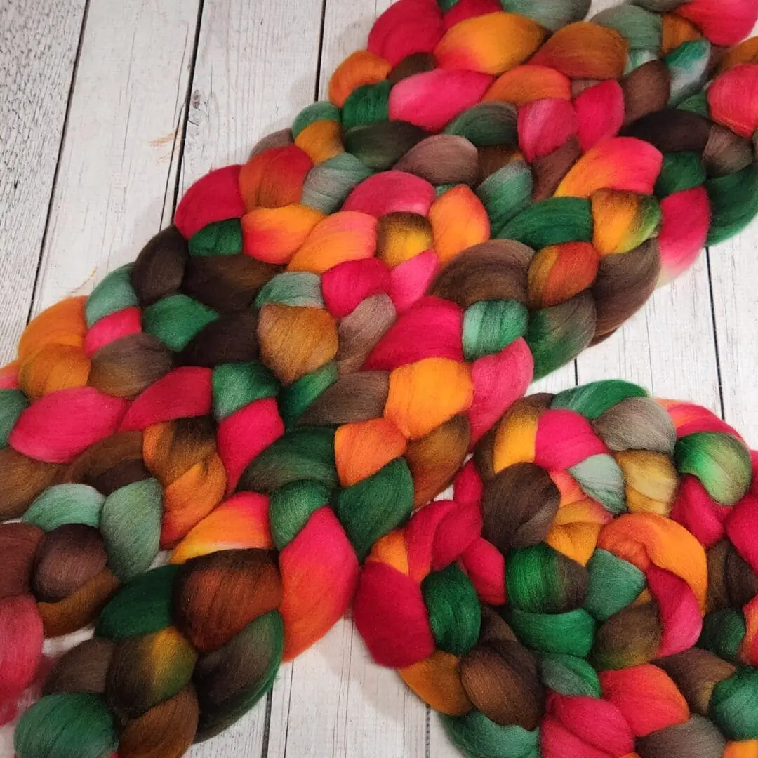 A bunch of colorful roving laying on top of a wooden surface.