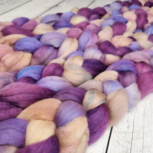 Purple and pink roving on a wooden table.