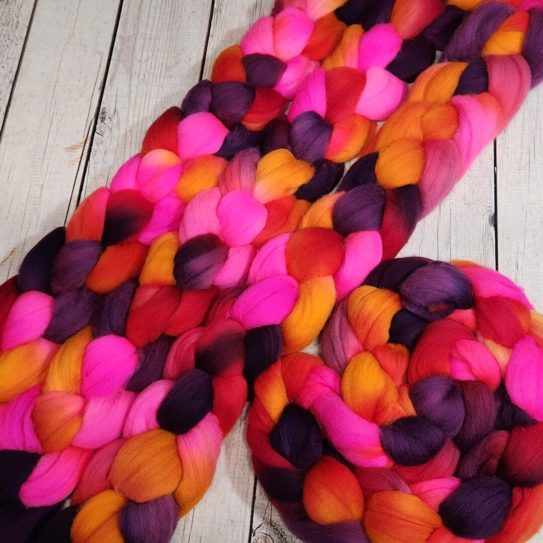 A bunch of colorful roving on a wooden surface.