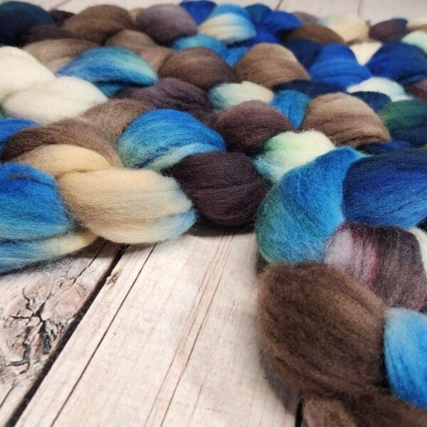 Blue and brown wool roving on a wooden table.