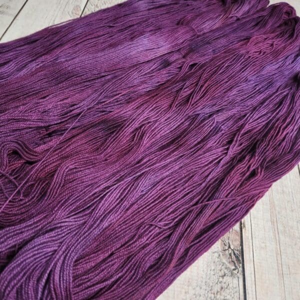 Purple dyed yarn on a wooden table.