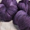 Purple skeins on a wooden table.