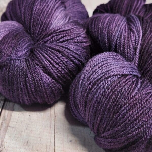 Purple skeins on a wooden table.