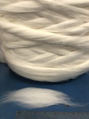 Fresh Lotus Design's Fiber Facts presents a ball of white wool on a table.