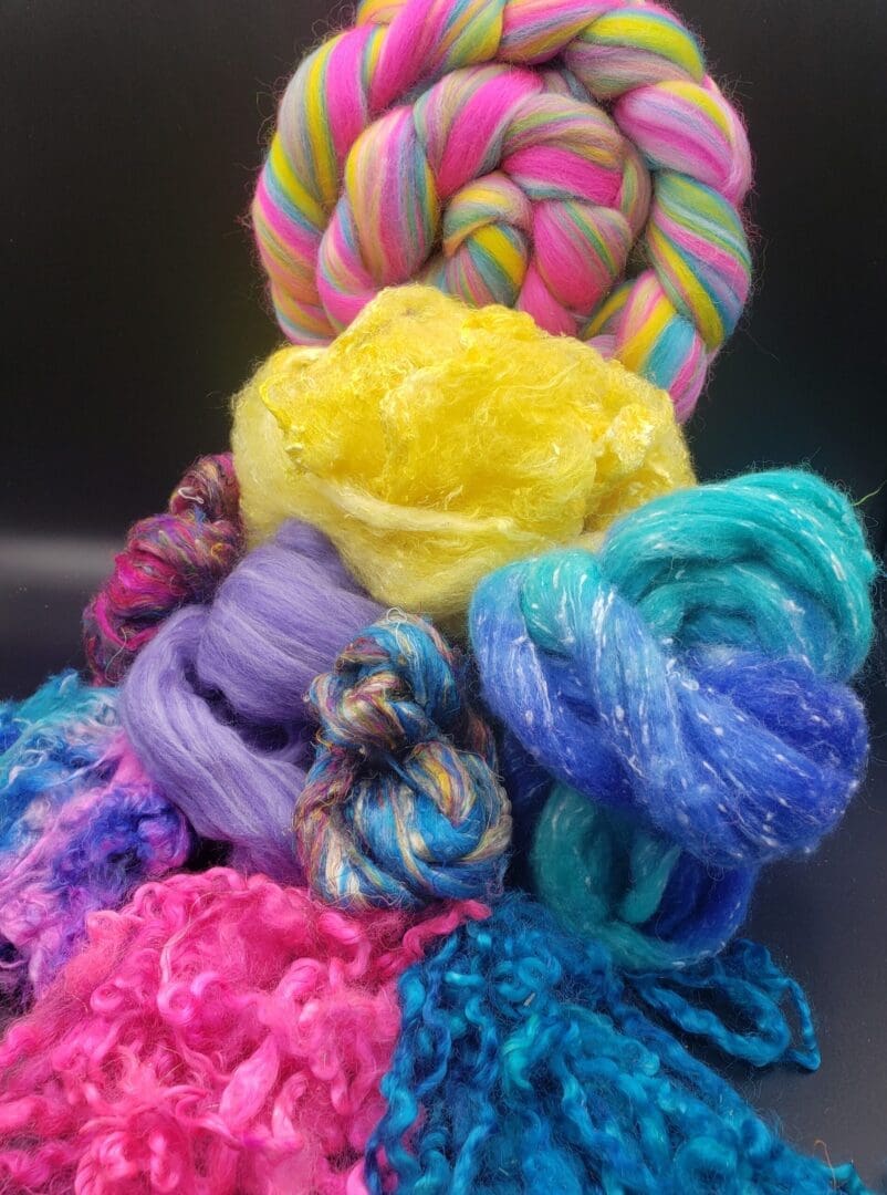 A bunch of colorful yarns laying on top of each other.