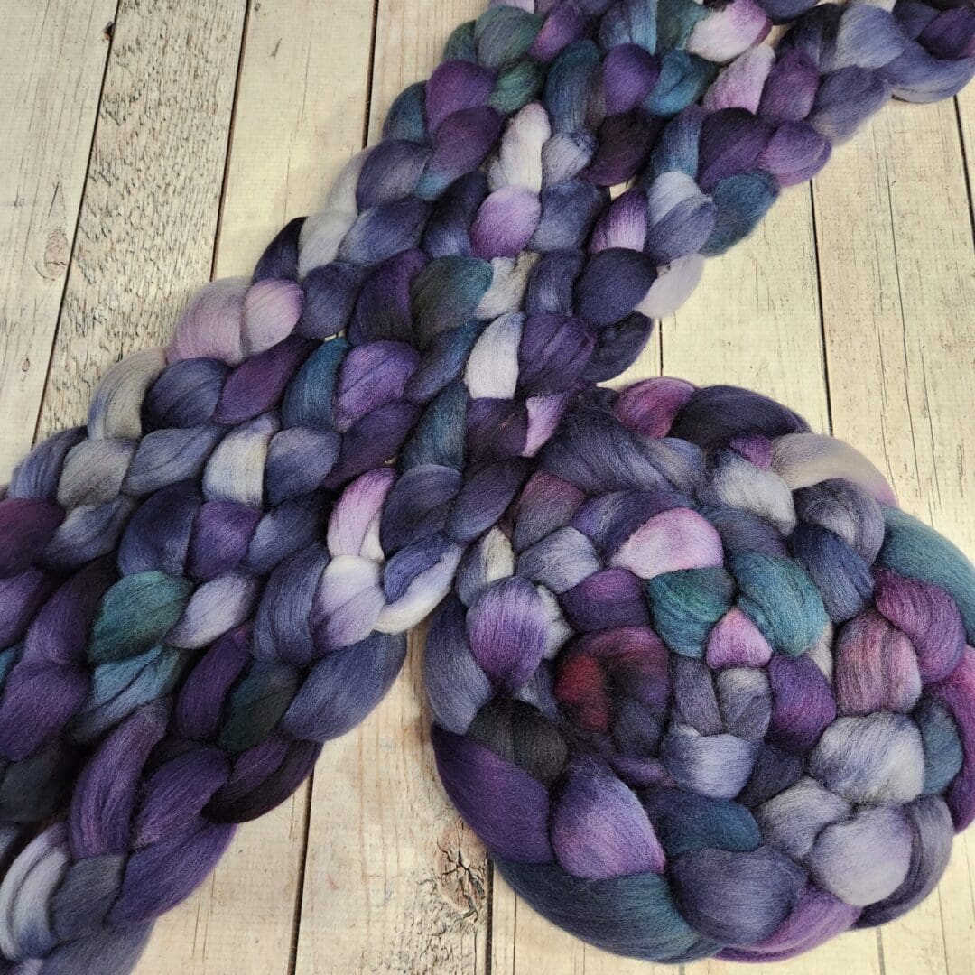 Purple and blue braided yarn on wood.