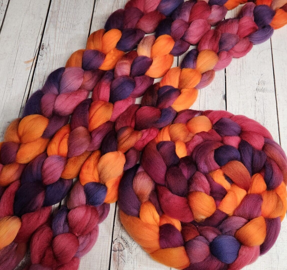 Braided yarn in orange, red, and purple.