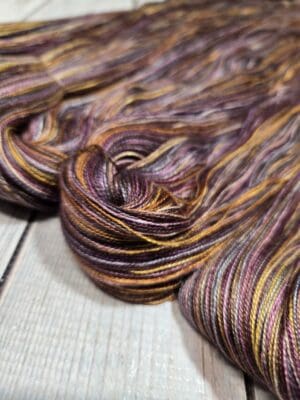 Variegated purple, gold, and brown yarn skein