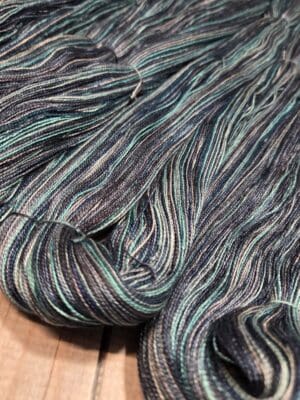 Variegated teal and navy hand-dyed yarn skein