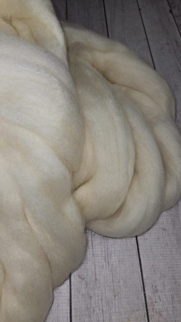 Cream wool roving on wooden floor
